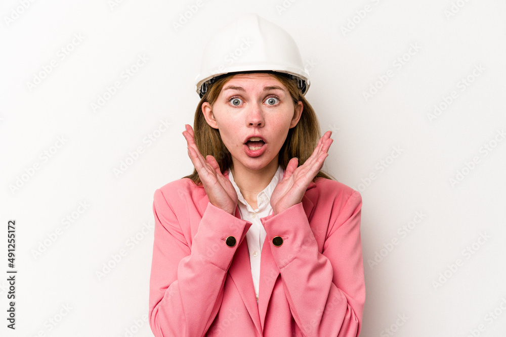 Young architect English woman with helmet isolated on white background surprised and shocked. Young architect English woman with helmet isolated on white background surprised and shocked.