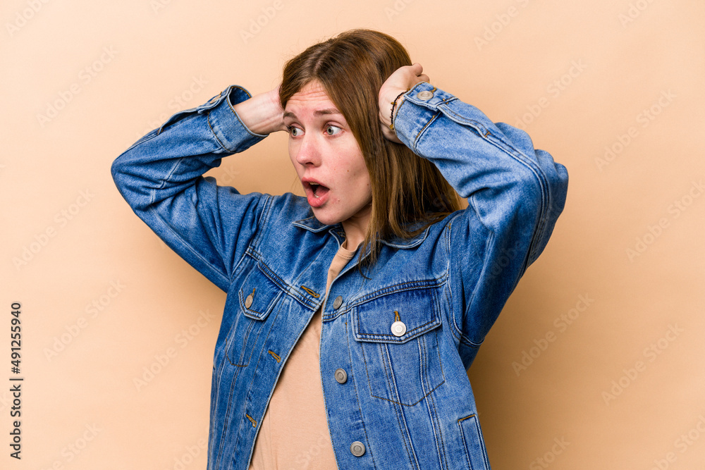 Young English woman isolated on beige background screaming, very excited, passionate, satisfied with something. Young English woman isolated on beige background screaming, very excited, passionate, satisfied with something.