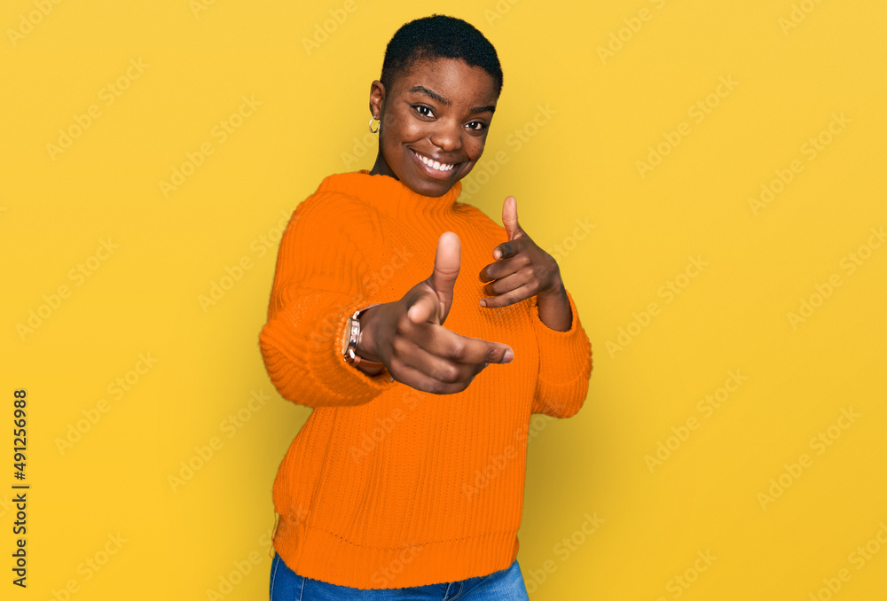 Young african american woman wearing casual clothes pointing fingers to camera with happy and funny face. good energy and vibes. Young african american woman wearing casual clothes pointing fingers to camera with happy and funny face. good energy and vibes.