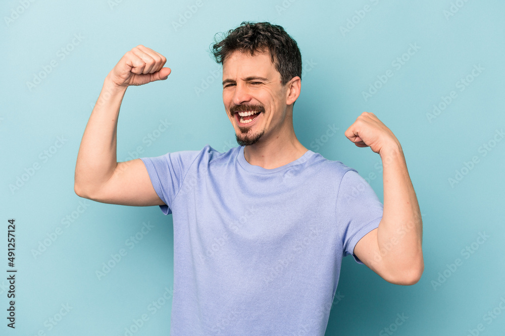 Young caucasian man isolated on blue background cheering carefree and excited. Victory concept. Young caucasian man isolated on blue background cheering carefree and excited. Victory concept.