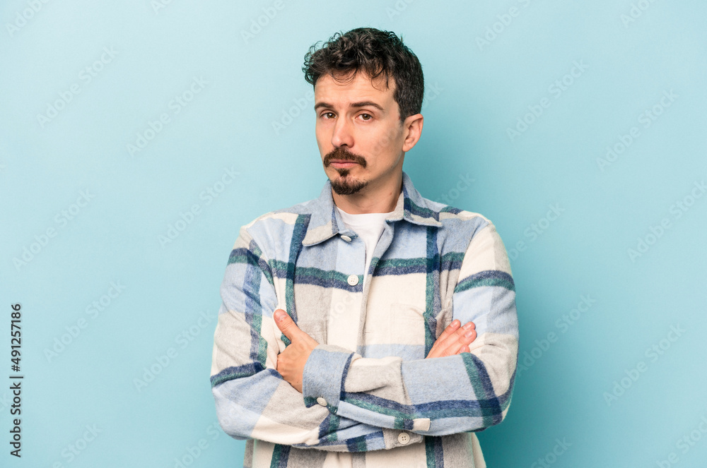 Young caucasian man isolated on blue background unhappy looking in camera with sarcastic expression. Young caucasian man isolated on blue background unhappy looking in camera with sarcastic expression.