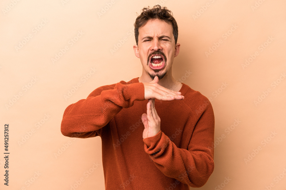 Young caucasian man isolated on beige background showing a timeout gesture. Young caucasian man isolated on beige background showing a timeout gesture.