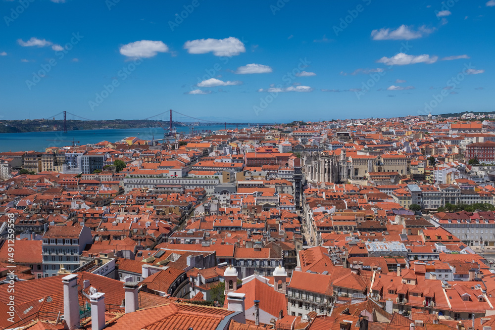 Lisbon historic city centre red roof houses Tagus river against cloudy sky