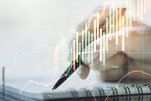 Abstract creative financial graph with hand writing in notebook on background, forex and investment concept. Multiexposure