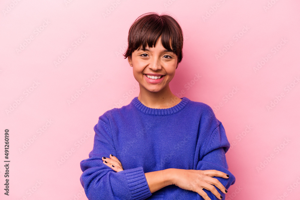 Fototapeta premium Young hispanic woman isolated on pink background who feels confident, crossing arms with determination.