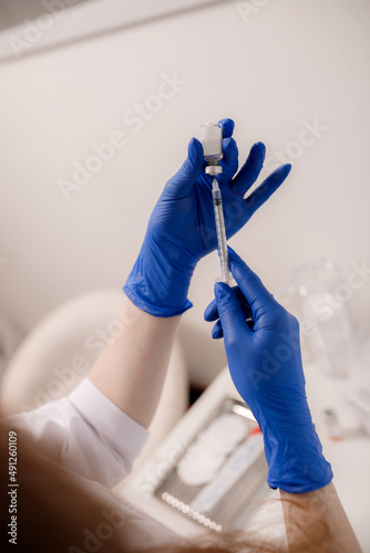 Girl beautician holds cosmetic tools - syringes, ampoules and skin care products