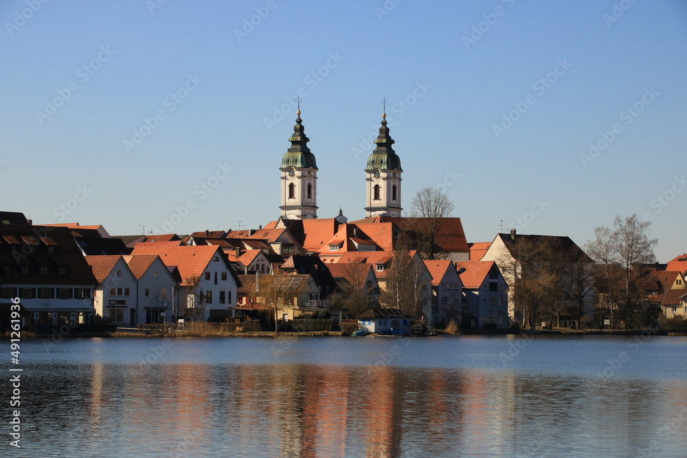 Blick auf den Ort Bad Waldsee. Die Türme der Stiftskirche spiegeln sich im Stadtsee