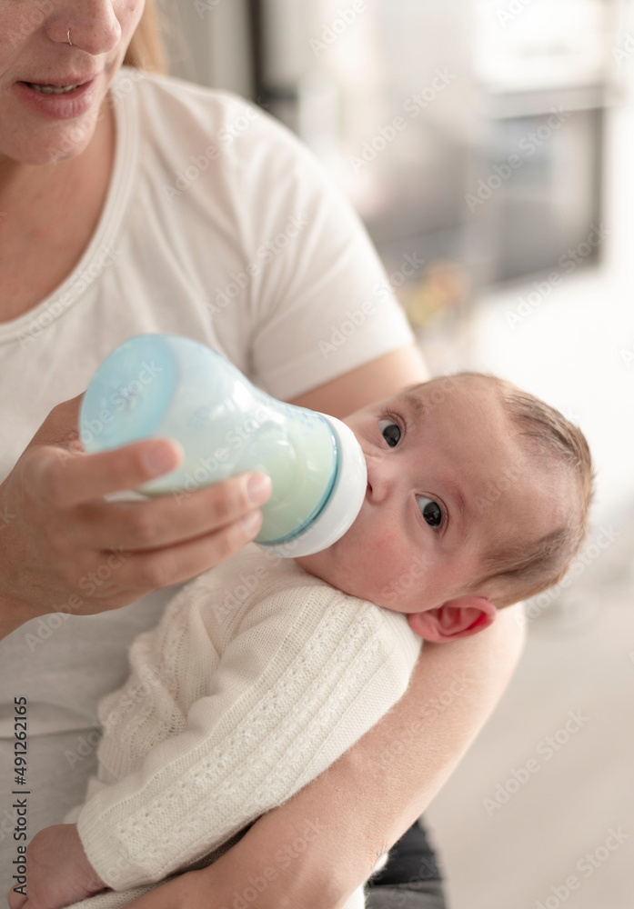 woman feeding the newborn baby with infant milk artificial nutrition. mother's love and warmth woman feeding the newborn baby with infant milk artificial nutrition. mother's love and warmth