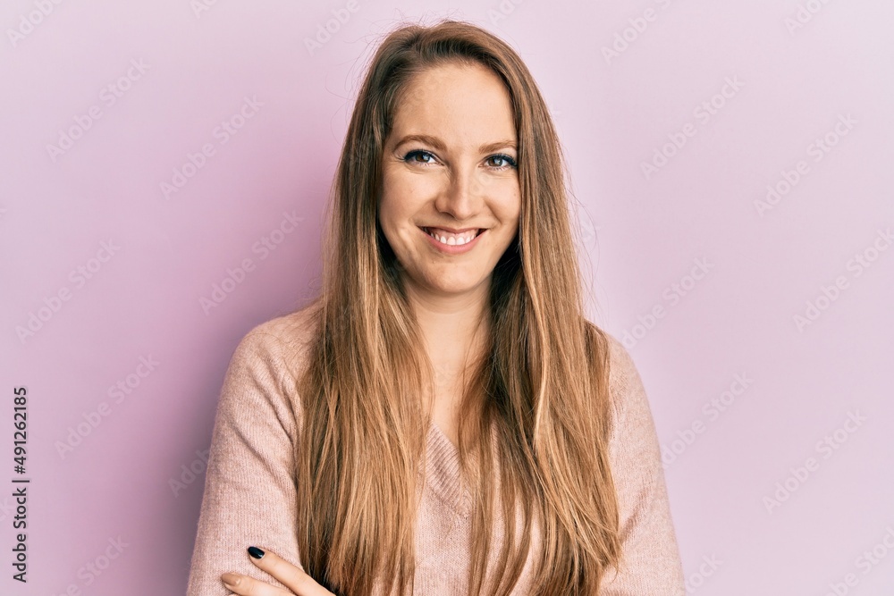 Young blonde woman wearing casual sweater happy face smiling with crossed arms looking at the camera. positive person. Young blonde woman wearing casual sweater happy face smiling with crossed arms looking at the camera. positive person.