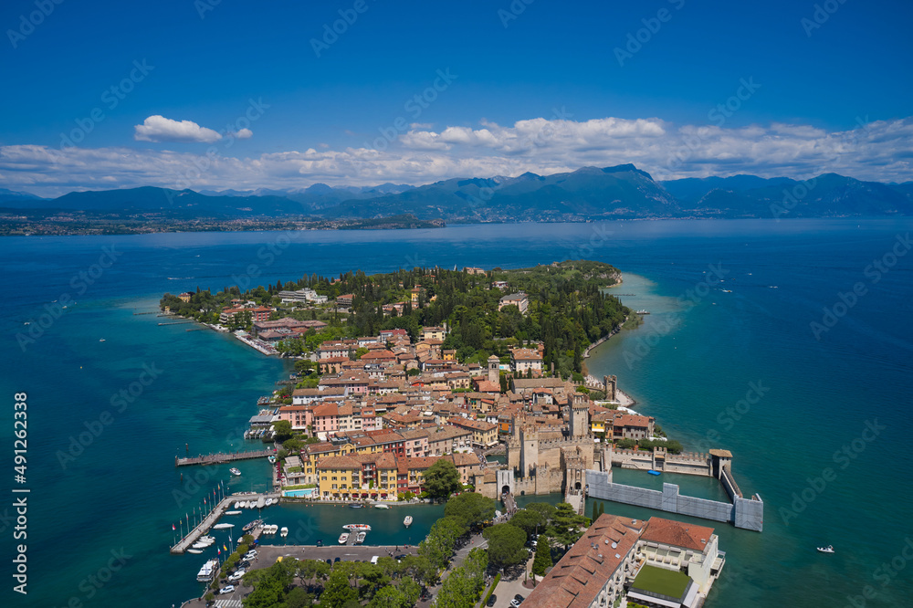 Sirmione, Lake Garda, Italy. Aerial Panorama of the island of Sirmione. Peninsula on a mountain lake in the background of the alps. Castle on the water in Italy.
