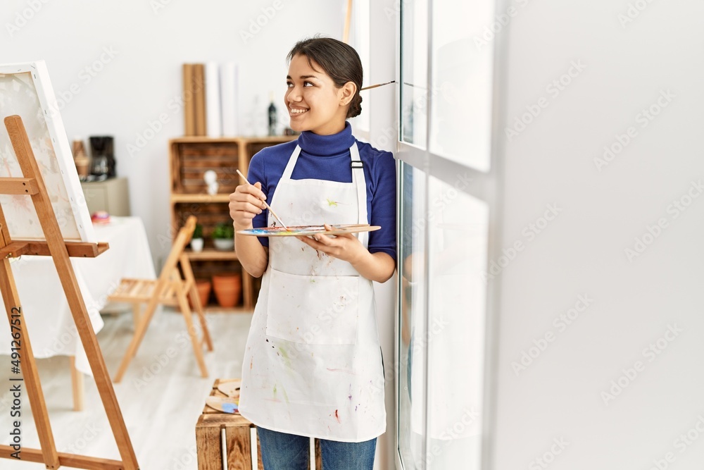 Young latin woman smiling confident mixing color on palette at art studio Young latin woman smiling confident mixing color on palette at art studio