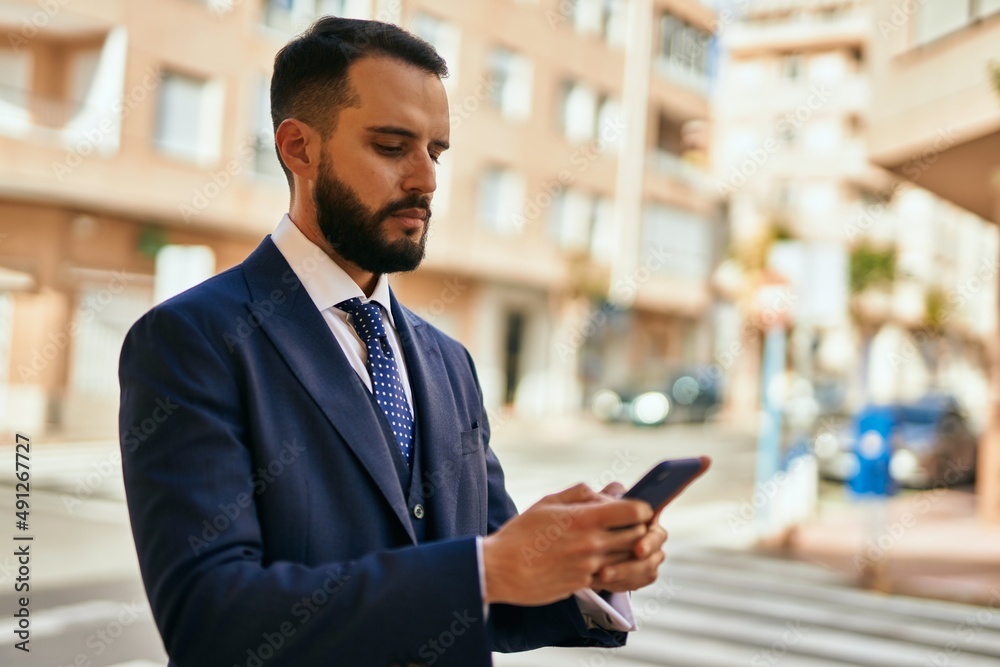 Young businessman with serious expression using smartphone at the city. Young businessman with serious expression using smartphone at the city.