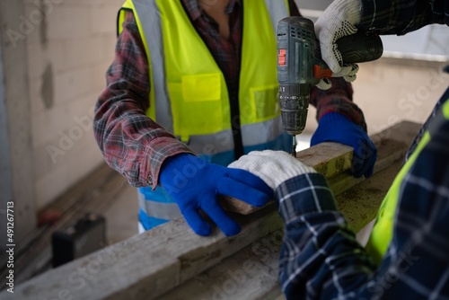 Close up to hand using an electric screwdriver and wearing personal protective equipment. Worker Wear gloves,PPE Work safe concept.Prevention concept.Work safe concept.Construction no harmful.