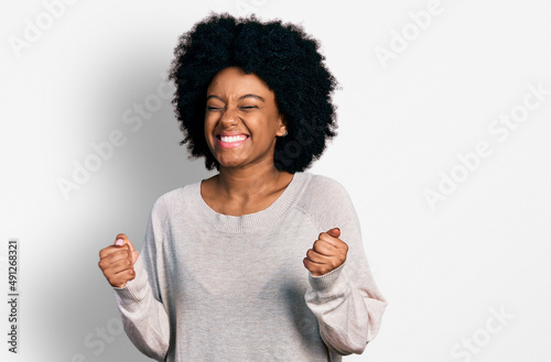 Obraz na plátně Young african american woman wearing casual clothes excited for success with arms raised and eyes closed celebrating victory smiling