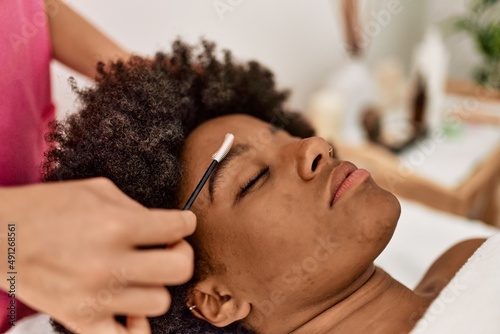 Young african american woman having eyebrows treatment at beauty center