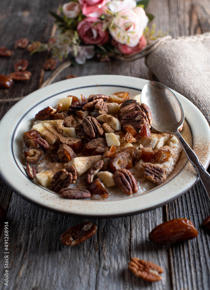 Breakfast bowl with porridge, pecan nuts, dates, bananas, apples and cinnamon Breakfast bowl with porridge, pecan nuts, dates, bananas, apples and cinnamon