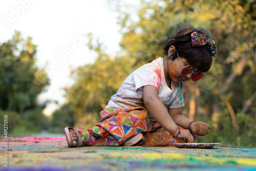 Colorful Holi Theme - Portrait Of Cute Indian Kid Wearing Round Colored Shades And Painted In Holi Color Powder Called Rang Gulal Abeer Or Abir
