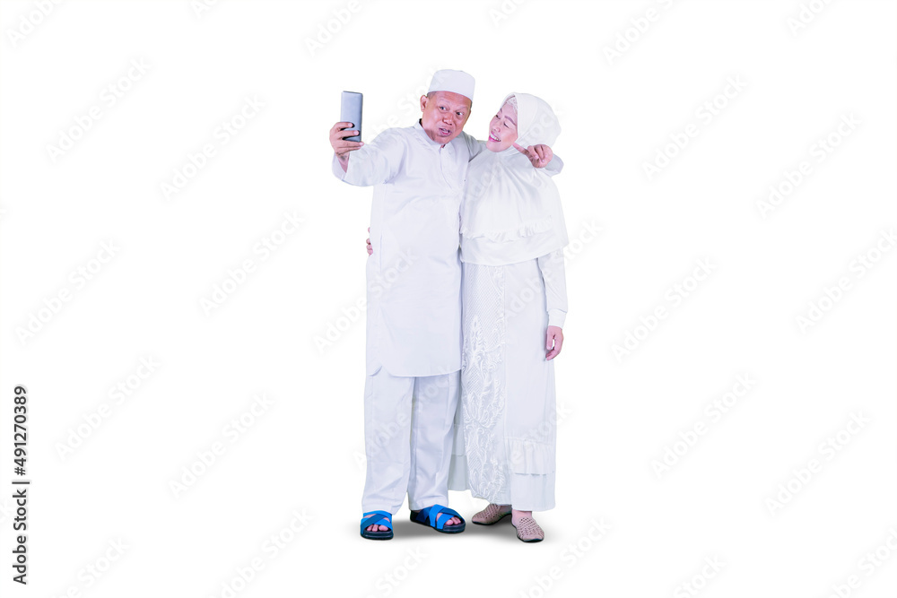 Muslim old couple doing video call at Eid on studio