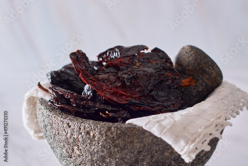 Fresh pasilla chilies on molcajete. Mexican culture. photo