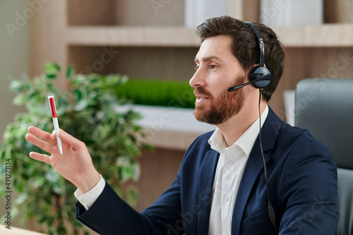 Representive practitioner leads online training wearing a suit and headset, with positive vibes and active gestures and explanations photo