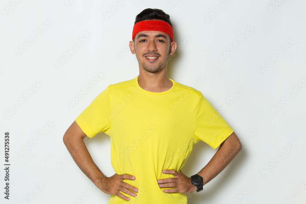 portrait young sporty man dressed in yellow tshirt on white background
