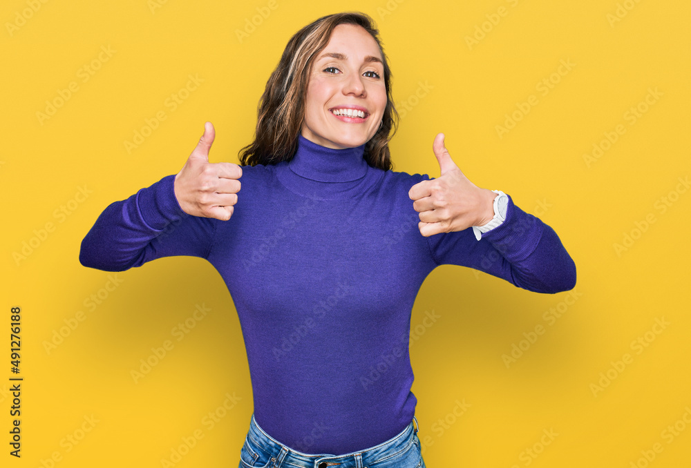 Young blonde woman wearing casual clothes success sign doing positive gesture with hand, thumbs up smiling and happy. cheerful expression and winner gesture.