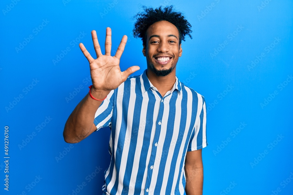 Young african american man with beard wearing casual striped shirt showing and pointing up with fingers number five while smiling confident and happy. Young african american man with beard wearing casual striped shirt showing and pointing up with fingers number five while smiling confident and happy.