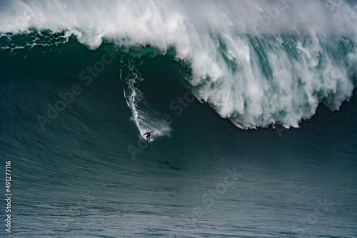 Professional athlete surfing a giant wave.