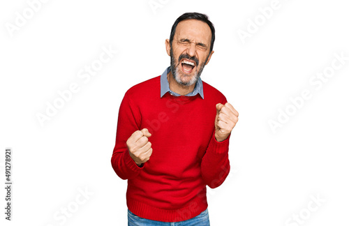 Middle age hispanic man wearing casual clothes very happy and excited doing winner gesture with arms raised, smiling and screaming for success. celebration concept.