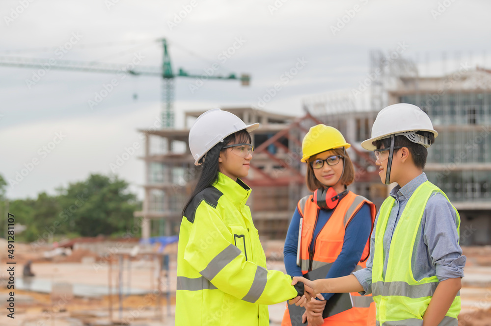 Young and senior Engineers discuss about work of large building underconstruction,Three people working on site of under construction Young and senior Engineers discuss about work of large building underconstruction,Three people working on site of under construction