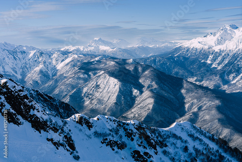 Winter mountain landscape. Caucasus ridge covered with snow in sunny day. Scenic mountain landscape with white-snow peaks .