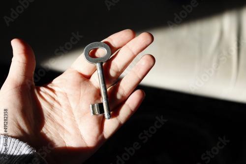 Close up of hand holding a key, Antique key on hand, Selective focus, Rusty mystic key.