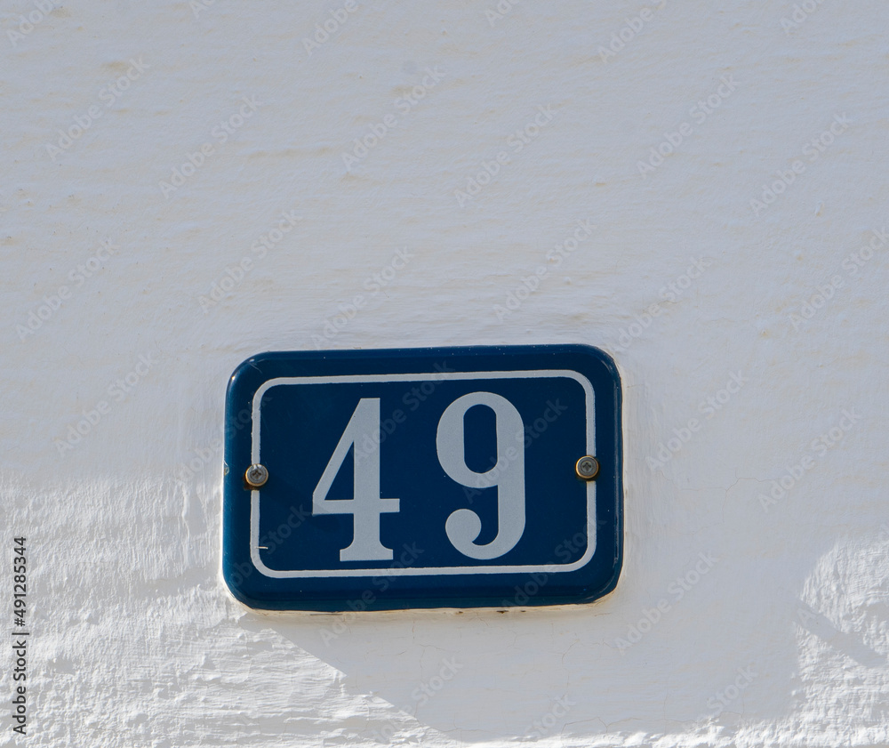 PLACA DEL NUMERO 49 EN UNA PARED BLANCA PLACA DEL NUMERO 49 EN UNA PARED BLANCA