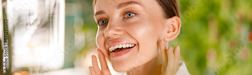 Closeup portrait of gorgeous young woman with smooth skin smiling while having beauty routine in the bathroom. Spa and wellness concept