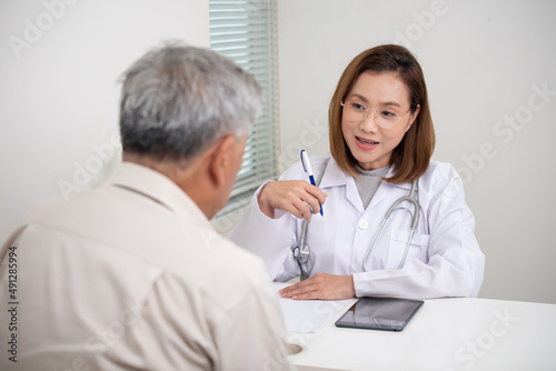 Asian Female Doctor examining old male patient in hospital