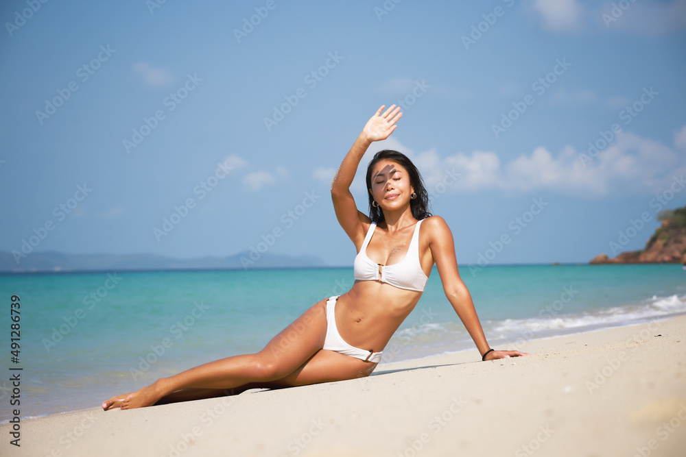 Portrait Tanned skin woman wearing swimming dress sunbathing on the beach,  Summer vacation lifestyle on beach of island