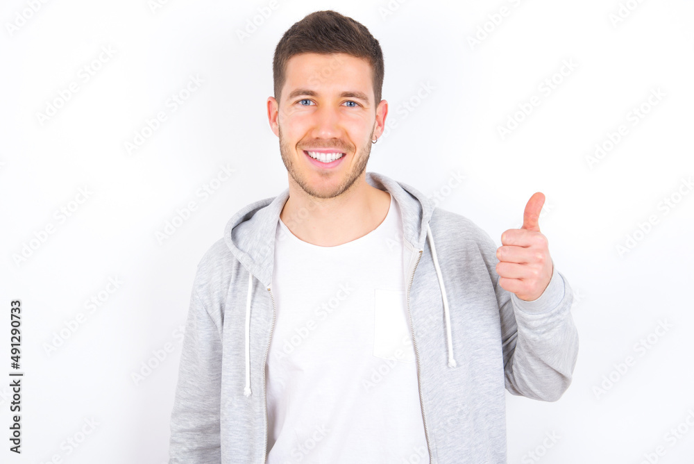 young caucasian man wearing casual clothes over white background giving thumb up gesture, good Job! Positive human emotion facial expression body language. young caucasian man wearing casual clothes over white background giving thumb up gesture, good Job! Positive human emotion facial expression body language.
