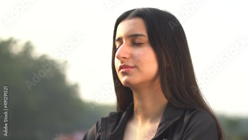 Young indian girl meditating in the park early in the morning. Young girl doing meditation. Healthy lifestyle concept.