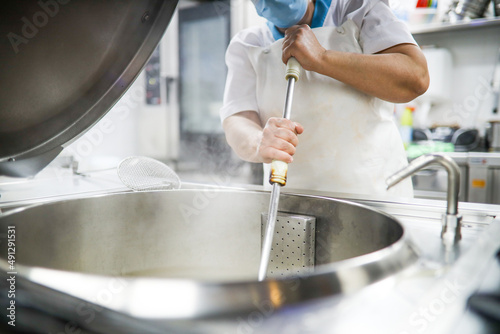 school kitchen in the middle of preparing the menu for the students who eat in the school dining room. unrecognizable cook preparing food