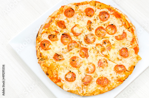Pepperoni and cheese pizza on a plate isolated on white background.