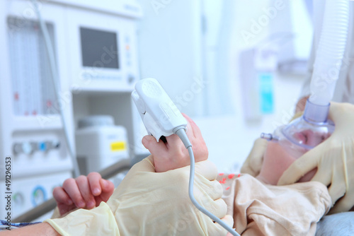 A device for measuring oxygen concentration.A close-up of a child's hand. Coming out of anesthesia. General anesthesia during surgery. The child's face is out of focus. photo