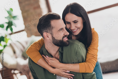 Portrait of attractive amorous sweet cheerful couple hugging spending time weekend day pastime at home house flat indoors photo
