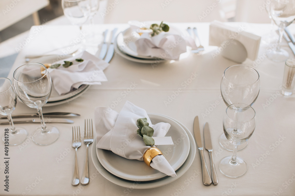 Elegant Place Setting with gold and white decoration in restaurant. Table set Elegant Place Setting with gold and white decoration in restaurant. Table set