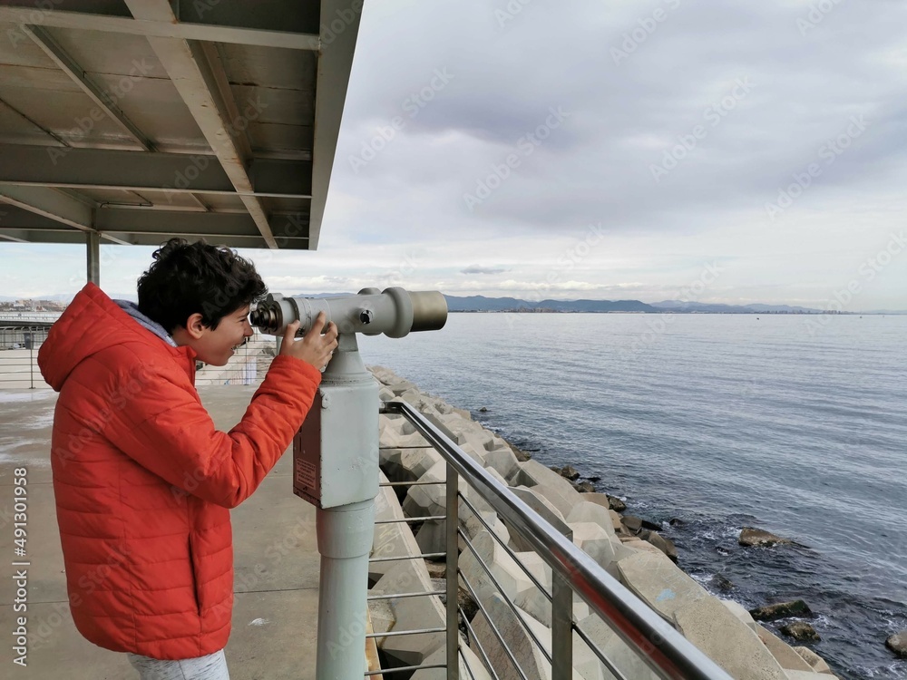 Obraz premium A person watches intently through some primates in the distant sea.