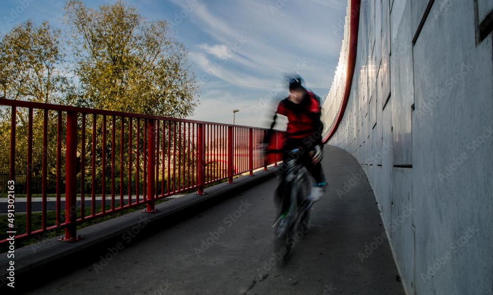 Miejska wycieczka rowerowa po ścieżce rowerowej w słoneczna jesienną pogodę - obrazy, fototapety, plakaty 