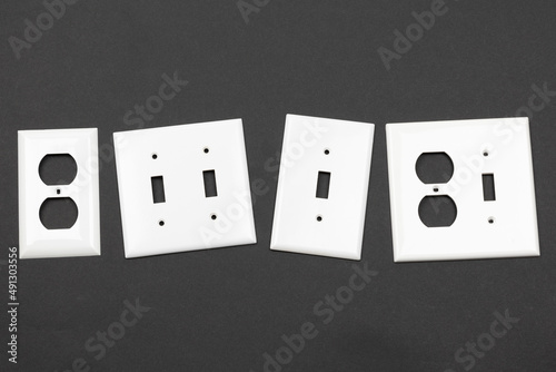 Collection of electrical face plates for outlets and switches in a flat layout on a black backround