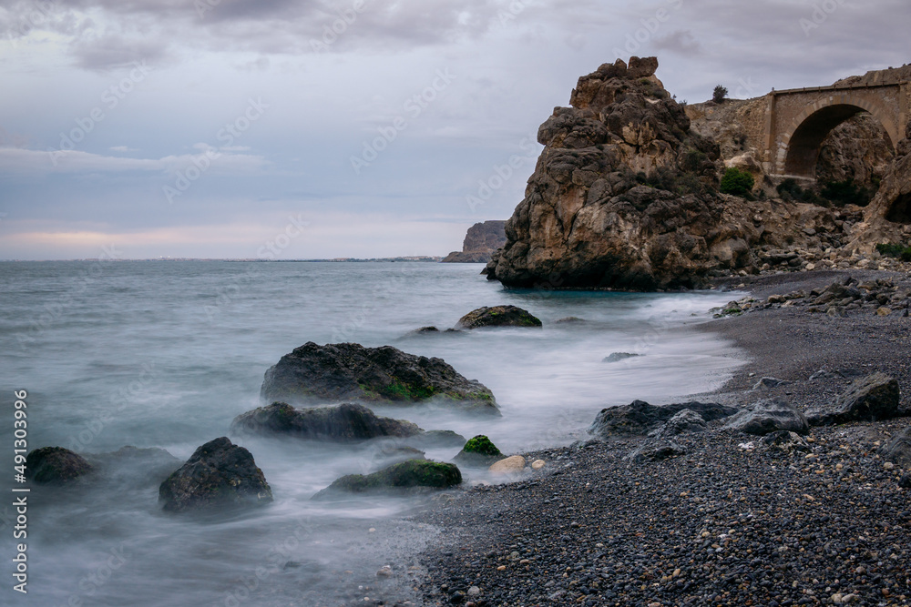 Obraz premium Beautiful nature landscape of Aguadulce Beach, located in Almeria, Spain with unique formation rocks, (Sunrise seascape ,Soft focus due to long exposure shot.)
