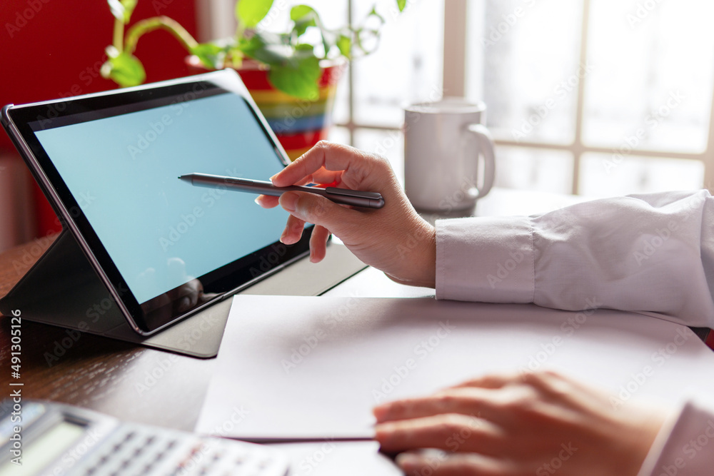 Woman using digital tablet with digital pencil, businesswoman or student. Working from home concept Woman using digital tablet with digital pencil, businesswoman or student. Working from home concept