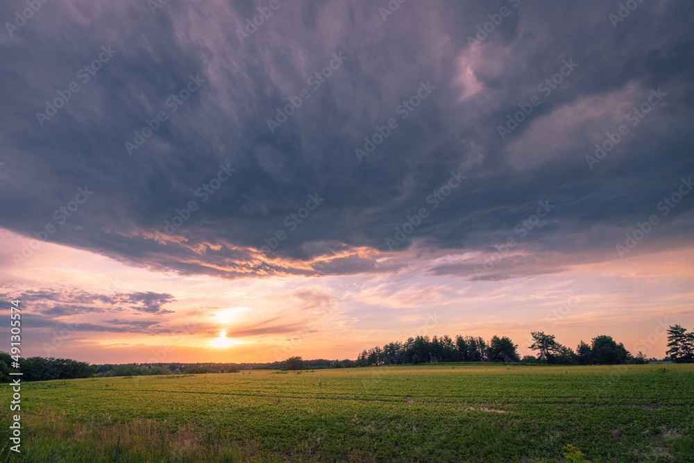 Dramatic stormy clouds over agriculture sunset summer field. Dramatic stormy clouds over agriculture sunset summer field.