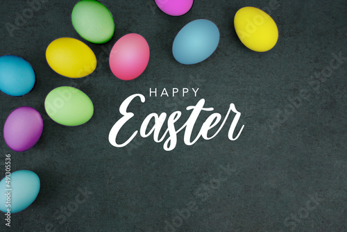 Happy Easter Text Card Design with Colored Easter Eggs Border Over Black Paper Background Texture